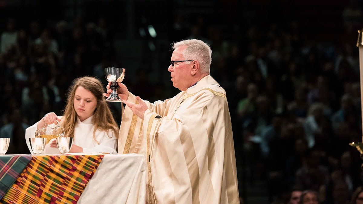 A priest and student conducting mass