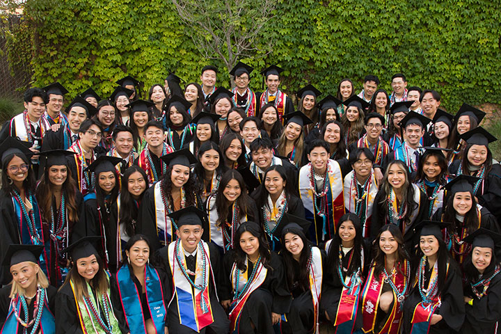 All Asian and Pacific Islander graduates in their cap and gowns wearing their new sashes
