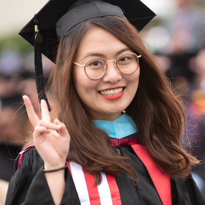 asian female grad making the peace sign