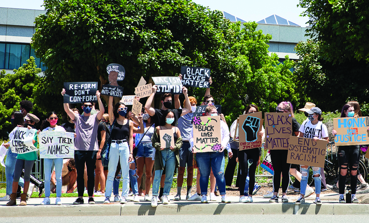 Students protesting with Black Lives Matter signs in front of campus
