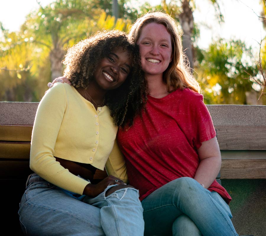 two women students sitting together smiling