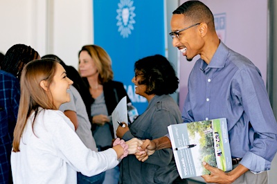 Female student shakes hands with Vocare Retreat presenter